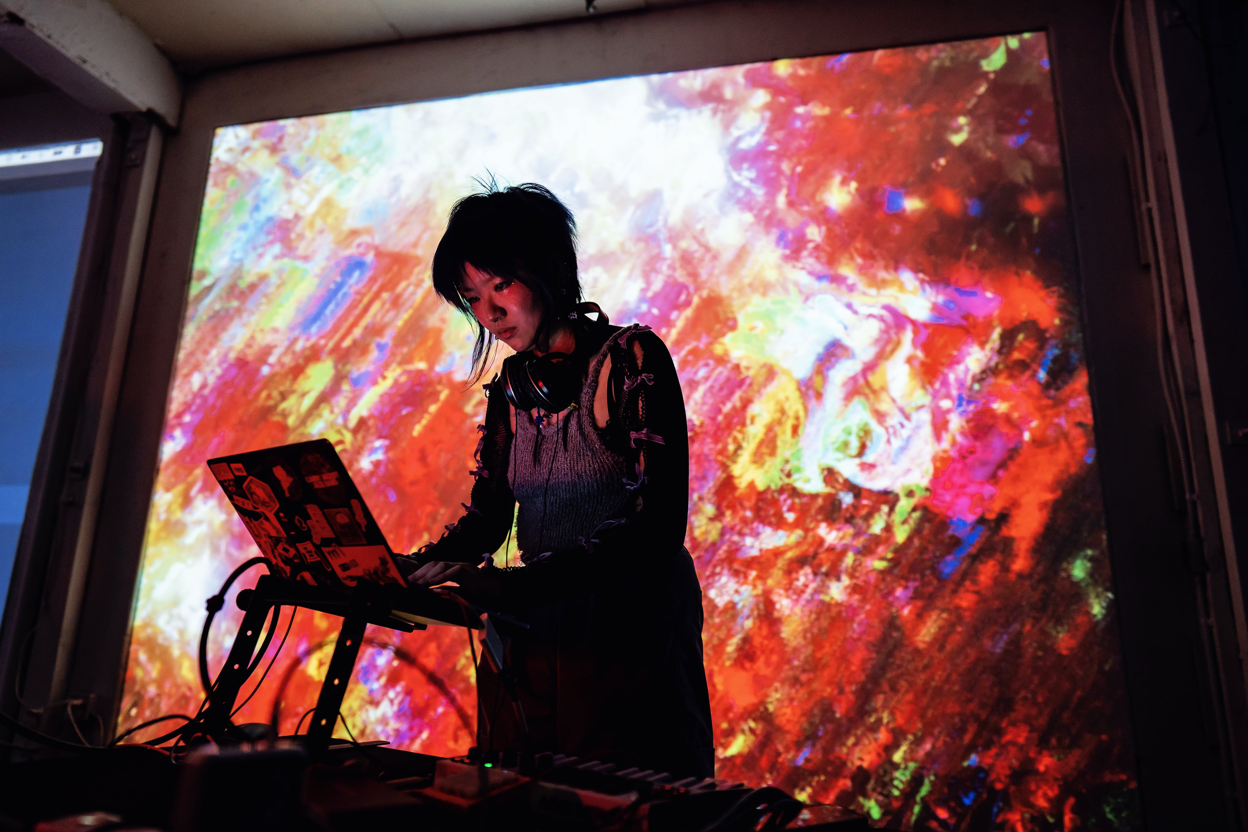 a photo of viola, looking down into a computer, with red projection graphics in the background